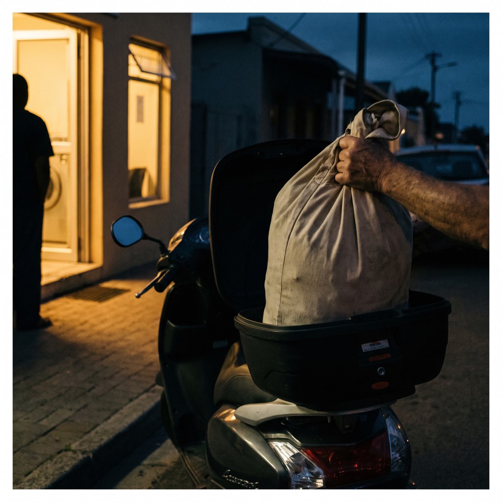 A laundry bag being handed over at a laundromat counter